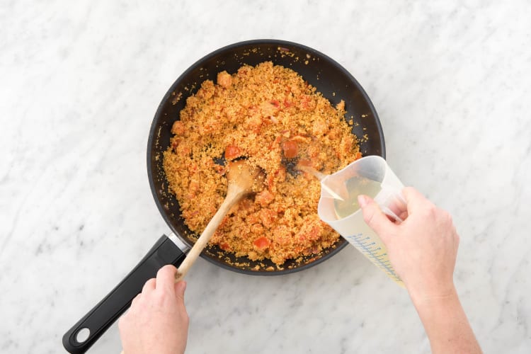 Schenk de bouillon over de couscous en laat de couscous, afgedekt, 10 minuten wellen.