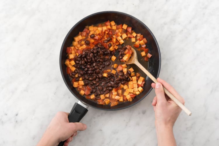 Ajouter le paprika en poudre fumé et les haricots noirs au wok