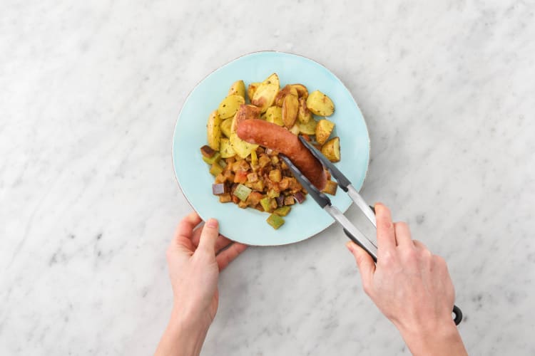 Servir la potée de légumes et la saucisse sur les assiettes