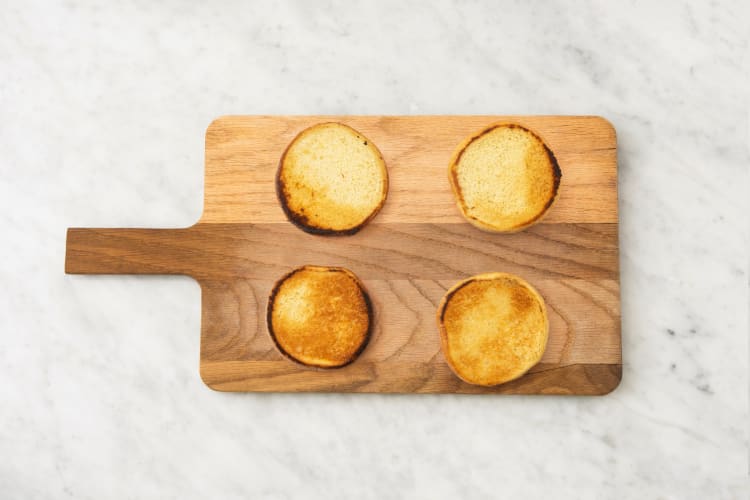 Toast buns and slice tomato