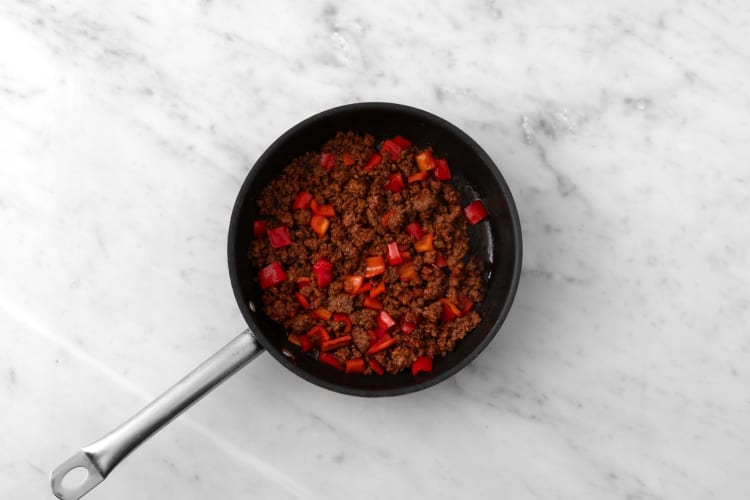 Cook plant-based protein shreds and peppers