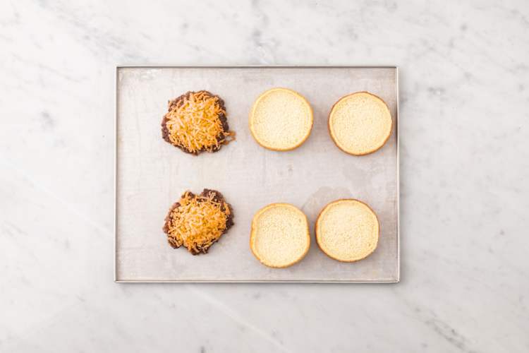 Toast buns and melt cheese