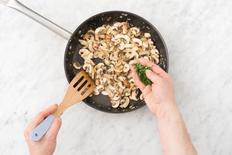 Breng de champignons op smaak met de helft van de peterselie.