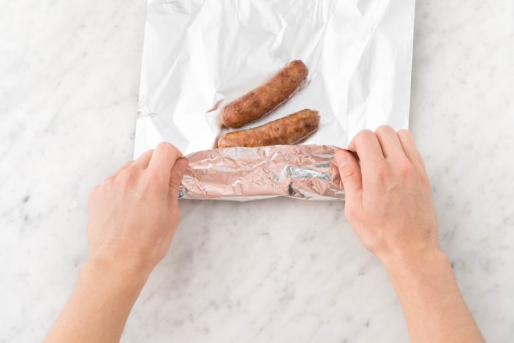 Envelopper les saucisses dans du papier aluminium.