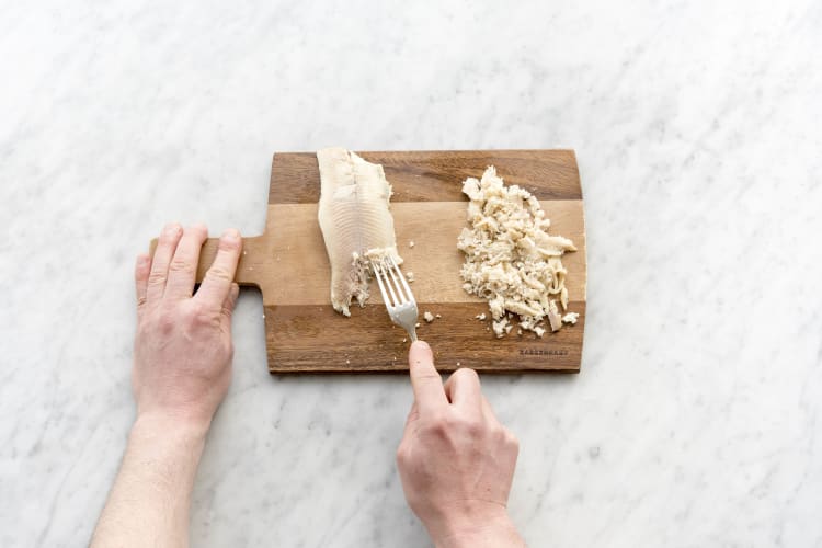 Verdeel de gerookte forel met een vork in kleine stukken