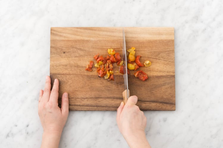 Snijd ondertussen de halfgedroogde rode en gele tomaten klein