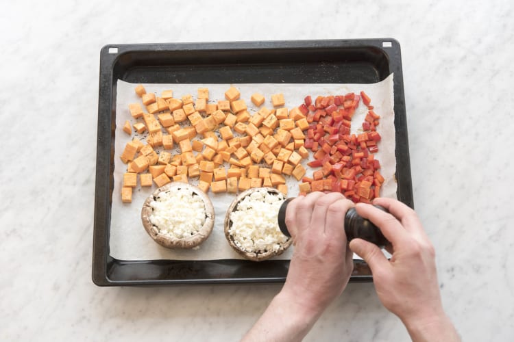 Bak de portobello en paprika de laatste 15 minuten met de bataat mee op de bakplaat