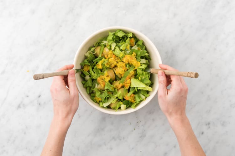 Meng in een saladekom de rauwe andijvie en de helft van de piccalilly door de sperziebonen en krieltjes en breng op smaak met peper en zout.