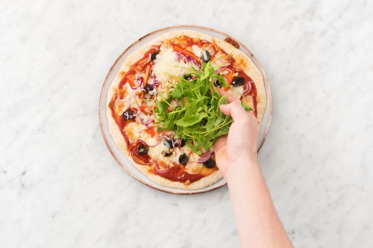 Serve the pizza with the dressed rocket