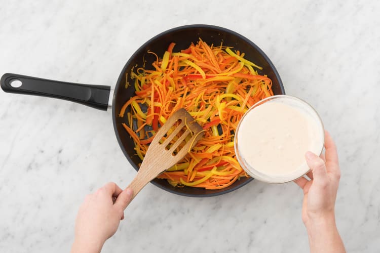 Voeg het pindakaas-kokosmengsel toe aan de wok of hapjespan met deksel