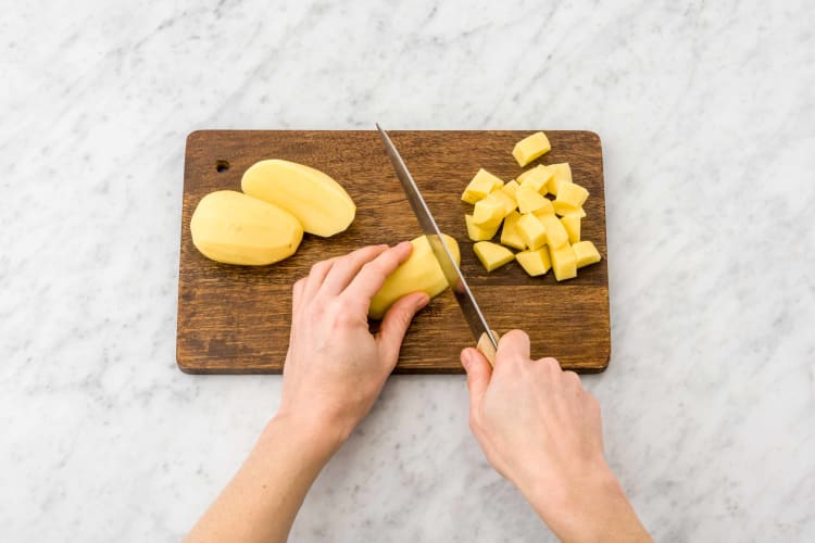 Was of schil de aardappelen en snijd in blokjes van 1 cm.