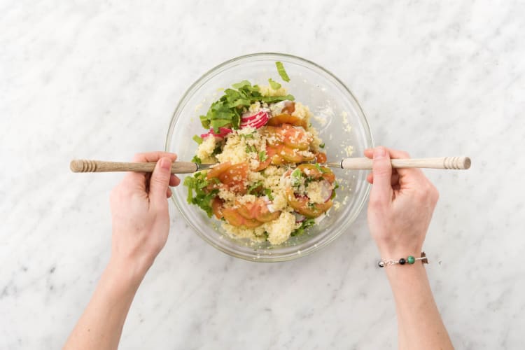 Meng de couscous met de overige yoghurt-tahinsaus, tomaat, radijsplakken en het radijsblad