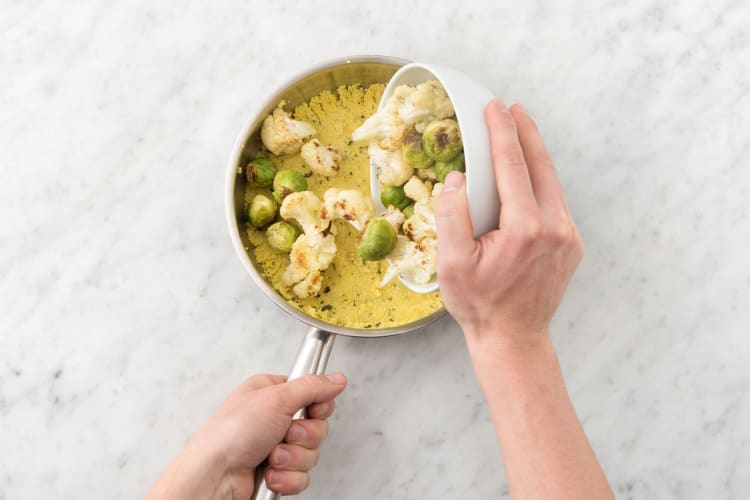 Voeg de groenten uit de oven toe aan de couscous.